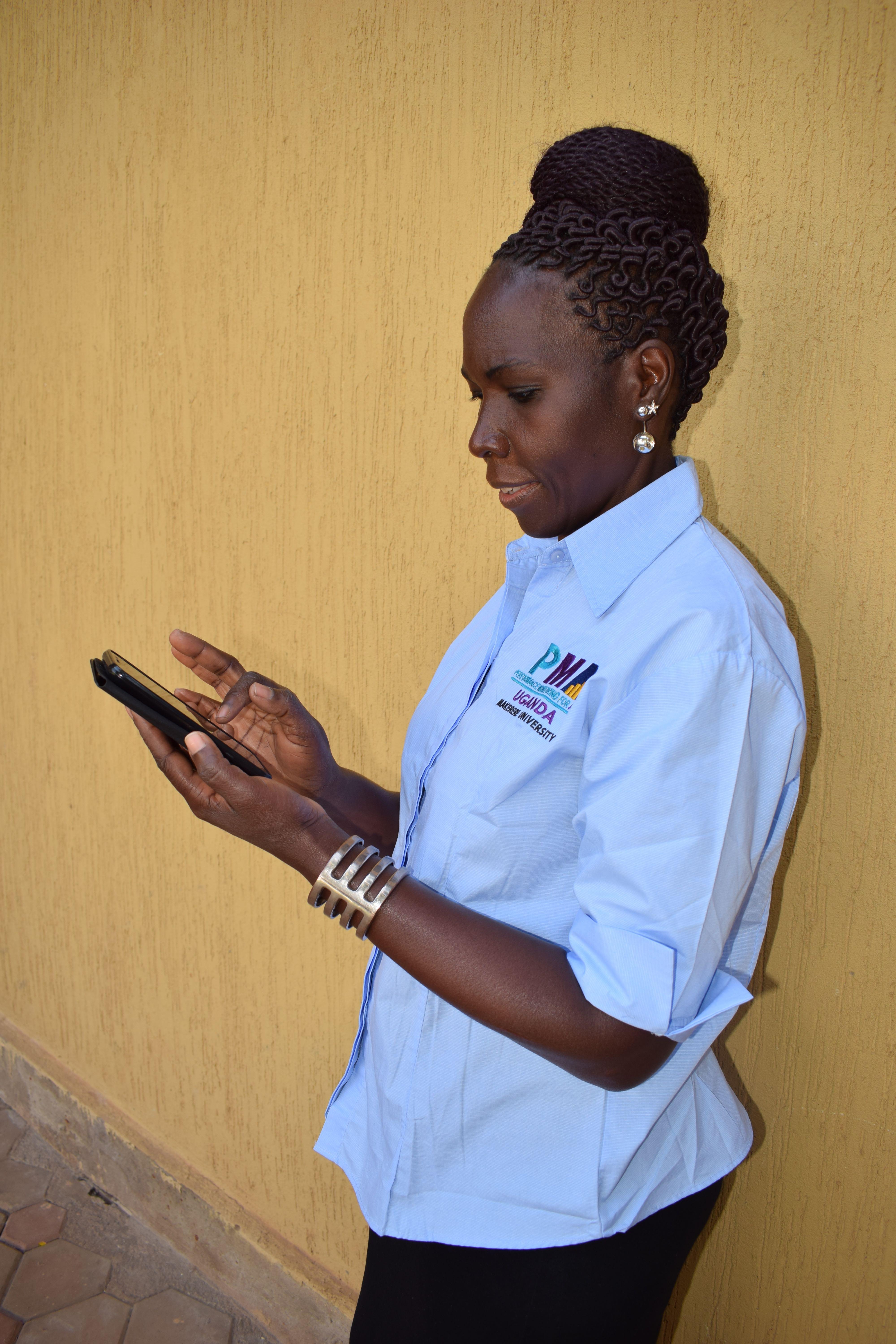 Ugandan woman working on mobile phone