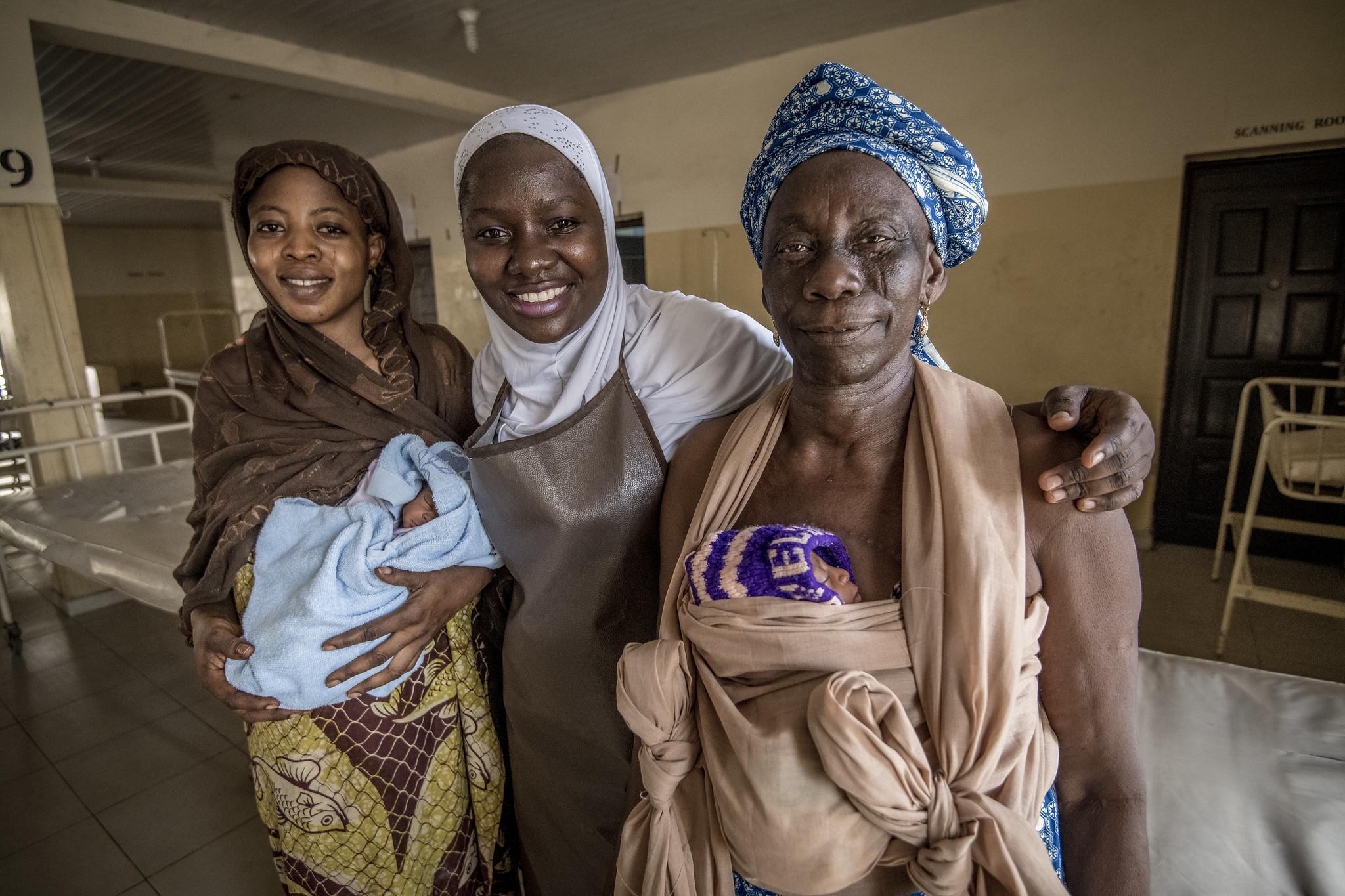 Three smiling women standing together with their arms around each other